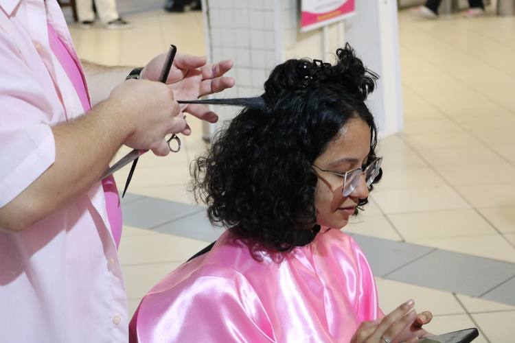 Aluna do Assunção realizando o corte de cabelo solidário