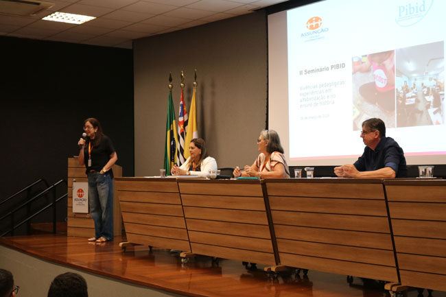 Prof.ª Ma. Juliana Pontes faz abertura do II Seminário do PIBID, enquanto Prof.ª Dr.ª Valéria Batista Edo, Prof.ª Dr.ª Solange Maria Fustinoni e Prof. Dr. Valmir Mendes compõe a mesa.