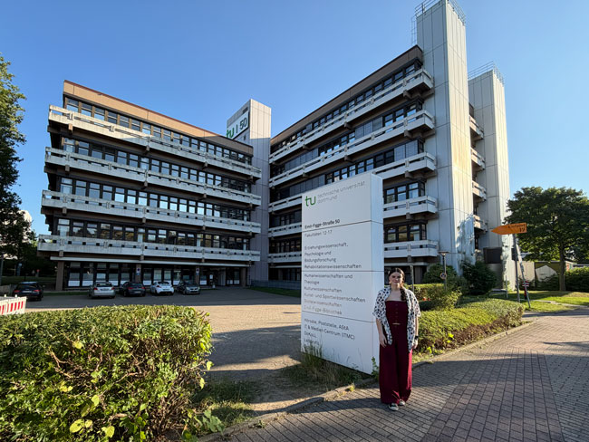 Prof.ª Karen Ambra no prédio da Faculdade de Ciências da Reabilitação, da TU Dortmund University, na Alemanha.