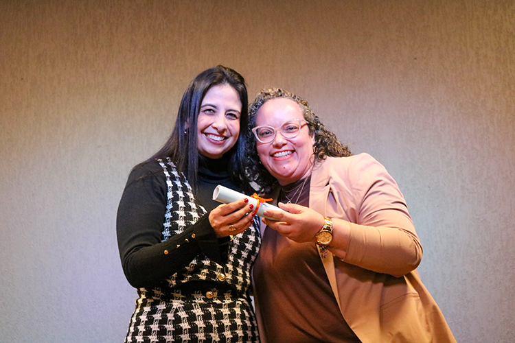 Prof.ª Daniela Dias com aluna após entrega de certificado. 
