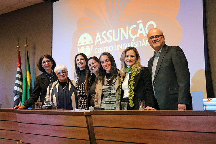 Mesa de honra com professores do Assunção e mestre de cerimônia, Prof.ª Me. Rosane Friedrich Câmara. 