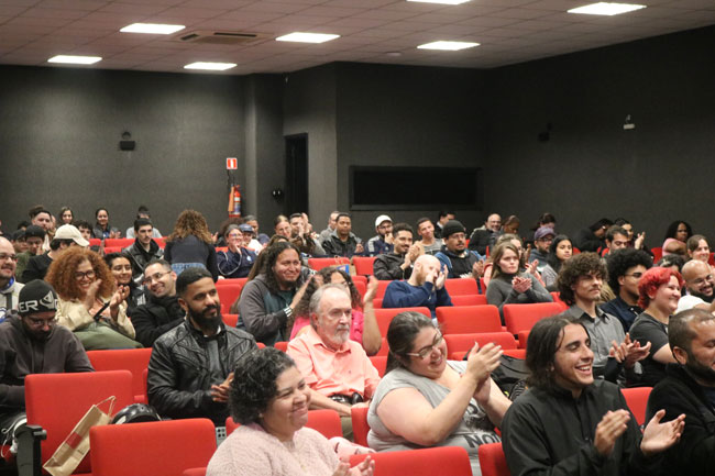Plateia cheia para lançamento do livro no Centro Universitário Assunção.