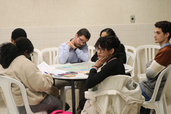 Participantes durante oficina do jogo “Pago ou Não”.