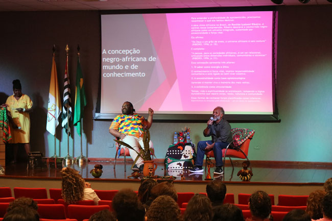 Palestrantes no palco do Centro Universitário Assunção