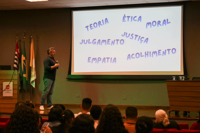 Prof. Me. Leandro da Silva Neves no palco do auditório durante palestra.